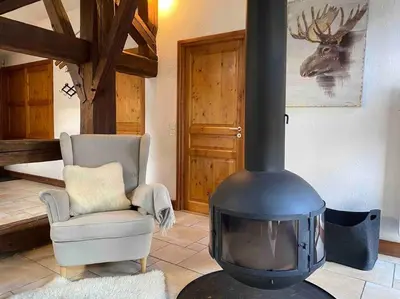 a living room with a fireplace and a chair at 90m2 hypercentre, terrace, next to ski lift in Chamonix-Mont-Blanc