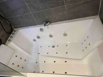 a white bath tub with a shower in a room at 90m2 hypercentre, terrace, next to ski lift in Chamonix-Mont-Blanc