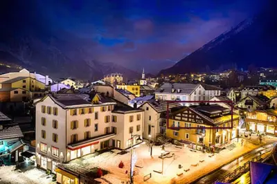 a city at night with mountains in the background at 90m2 hypercentre, terrace, next to ski lift in Chamonix-Mont-Blanc