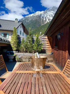 a wooden table on a patio with a mountain at 90m2 hypercentre, terrace, next to ski lift in Chamonix-Mont-Blanc