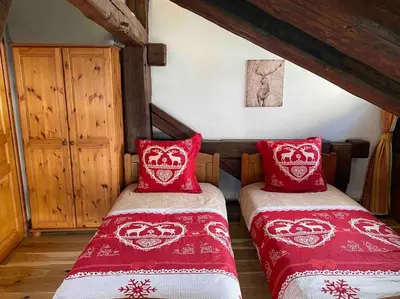 two beds in a bedroom with red and white blankets at 90m2 hypercentre, terrace, next to ski lift in Chamonix-Mont-Blanc