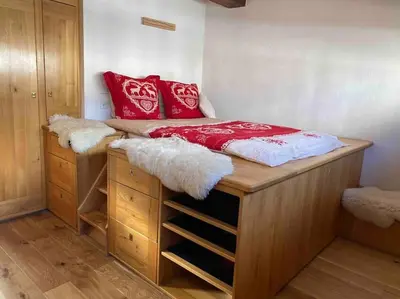 a bed with red pillows on top of it in a bedroom at 90m2 hypercentre, terrace, next to ski lift in Chamonix-Mont-Blanc