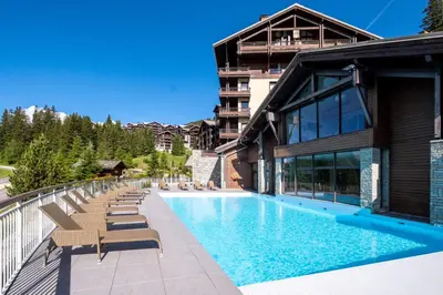 a swimming pool with snow covered mountains in the background at Résidence Pierre & Vacances Premium Les Terrasses d'Eos in Flaine