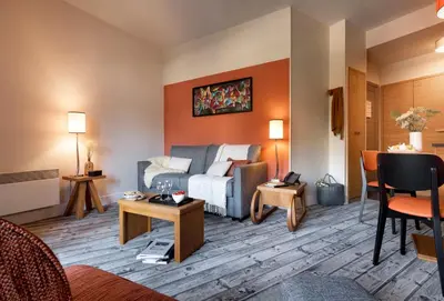 a kitchen with wooden cabinets and a table with chairs at Résidence Pierre & Vacances Premium Les Terrasses d'Eos in Flaine