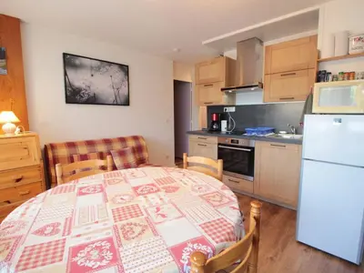 a kitchen with a table and a white refrigerator at Appartement cosy 2 pièces pour 4 pers, proche centre et pistes, avec balcon, parking et équipements inclus - FR-1-572-236 in Arâches-la-Frasse