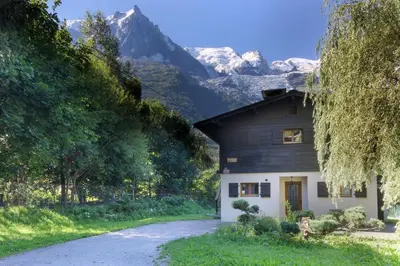 a house on a road with mountains in the background at Violette de Cham - Jardin privé - Vue Mont Blanc in Chamonix-Mont-Blanc
