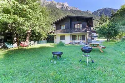 a house with a grill and a table in the yard at Violette de Cham - Jardin privé - Vue Mont Blanc in Chamonix-Mont-Blanc