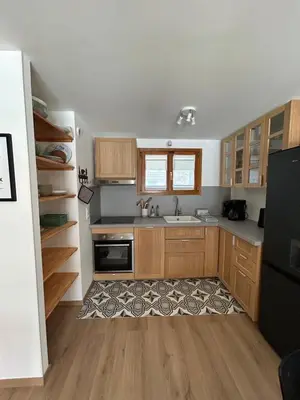 a kitchen with wooden cabinets and a sink at Violette de Cham - Jardin privé - Vue Mont Blanc in Chamonix-Mont-Blanc