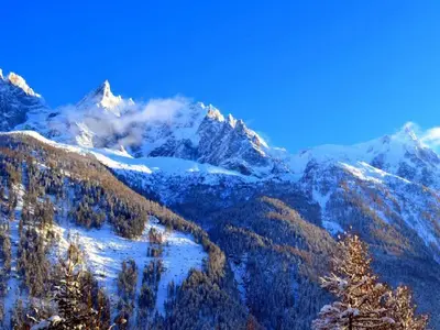 a snow covered mountain range with trees and snow at La Rivière - Aiguille du Midi in Chamonix-Mont-Blanc