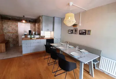 a kitchen with a white table and black chairs at La Rivière - Aiguille du Midi in Chamonix-Mont-Blanc