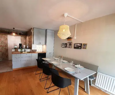 a dining room with a table and chairs and a kitchen at La Rivière - Aiguille du Midi in Chamonix-Mont-Blanc