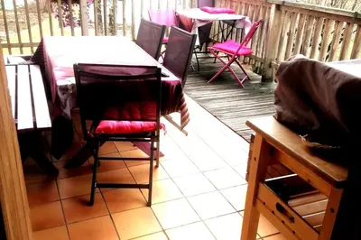 a table and chairs on a porch with a table and chairs at Le chalet de Julbert in Combloux