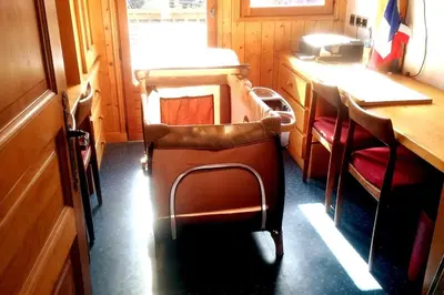 a train room with chairs and a table and a counter at Le chalet de Julbert in Combloux