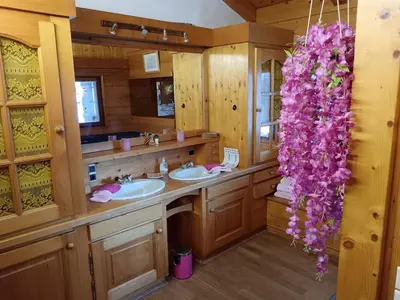 a bathroom with two sinks and purple flowers at Le chalet de Julbert in Combloux