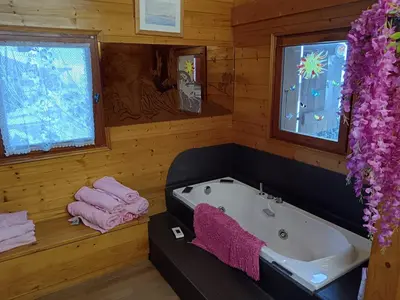 a bathroom with a bath tub and two windows at Le chalet de Julbert in Combloux