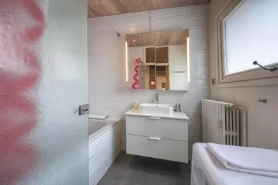 a white bathroom with a sink and a mirror at Gaillands North in Chamonix-Mont-Blanc