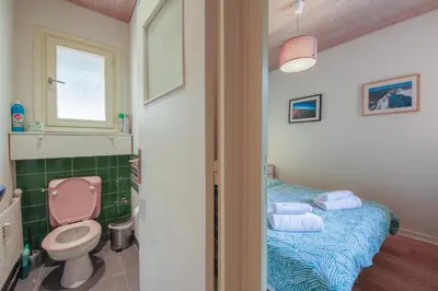 a bathroom with a bed and a toilet and a window at Gaillands North in Chamonix-Mont-Blanc