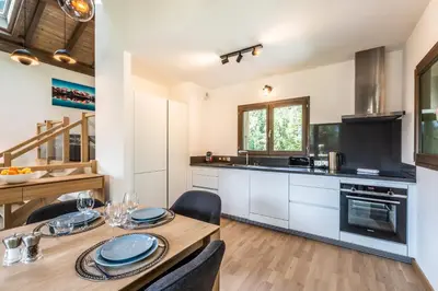 a kitchen with a wooden table and a dining room at Chalet Jatoba Chamonix - by EMERALD STAY in Chamonix-Mont-Blanc