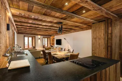a kitchen and dining room with a table and a living room at Maison du Roi - Happy Rentals in Chamonix-Mont-Blanc