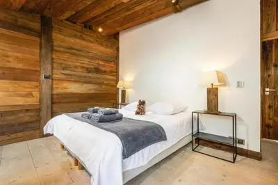 a bedroom with a white bed with wooden walls at Maison du Roi - Happy Rentals in Chamonix-Mont-Blanc