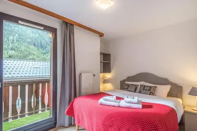 a bedroom with a bed and a large window at Joli appartement vue Mont Blanc 3 balcons et parking - Welkeys in Chamonix-Mont-Blanc