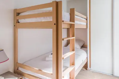 a bunk bed room with two bunk beds and a mirror at Joli appartement vue Mont Blanc 3 balcons et parking - Welkeys in Chamonix-Mont-Blanc