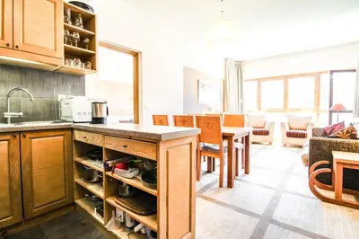 a kitchen with wooden cabinets and a counter top at Bright spacious two bed South facing family apartment in Flaine