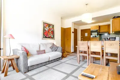 a living room with a couch and a table at Bright spacious two bed South facing family apartment in Flaine