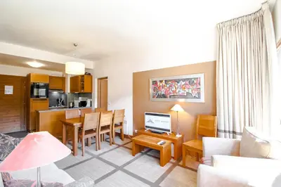 a living room with a kitchen and a dining room at Bright spacious two bed South facing family apartment in Flaine
