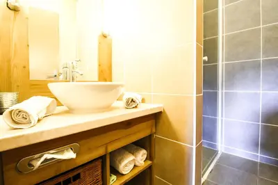 a bathroom with a sink and a shower at Bright spacious two bed South facing family apartment in Flaine