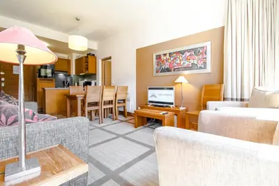 a living room with a couch and a dining room at Bright spacious two bed South facing family apartment in Flaine