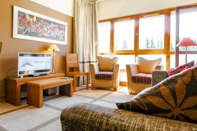 a living room with a couch and a tv at Bright spacious two bed South facing family apartment in Flaine