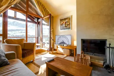a living room with a fireplace and a tv at Exceptional 3 bed Penthouse with fireplace and stunning views in Flaine