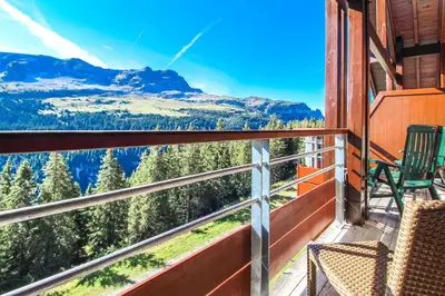 a balcony with chairs and a view of the mountains at Exceptional 3 bed Penthouse with fireplace and stunning views in Flaine