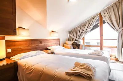 a hotel room with two beds and a window at Exceptional 3 bed Penthouse with fireplace and stunning views in Flaine