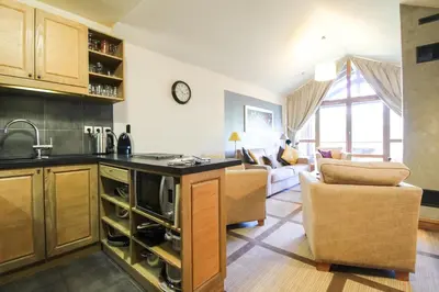 a kitchen and living room with a couch and a table at Exceptional 3 bed Penthouse with fireplace and stunning views in Flaine