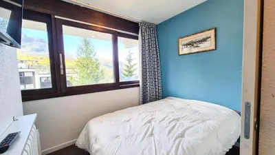 a small bedroom with a bed and a window at Résidence Les Terrasses De Veret - Appartement lumineux · Au pied des pistes · Piscine · Spa MAE-5444 in Flaine