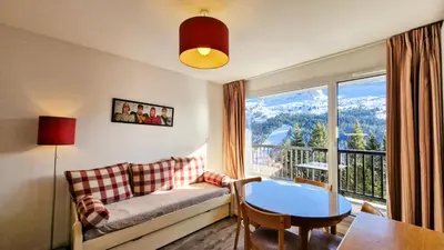 a living room with a couch and a table and a window at Résidence Les Pleiades - Appartement confortable · Centre station · Balcon · Parking couvert MAE-5454 in Flaine