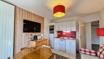 a kitchen with a wooden table in a room at Résidence Les Pleiades - Appartement confortable · Centre station · Balcon · Parking couvert MAE-5454 in Flaine