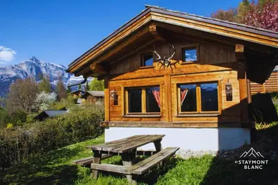 a log cabin with a picnic bench in front of it at Chalet cosy proche Tramway du Mont-Blanc et centre in Saint-Gervais-les-Bains