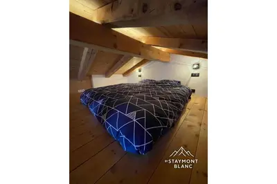 a bed in the attic of a room at Chalet cosy proche Tramway du Mont-Blanc et centre in Saint-Gervais-les-Bains
