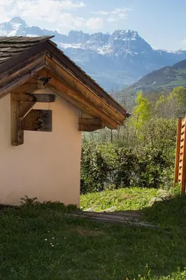 a building with a sign on it with mountains in the background at Chalet cosy proche Tramway du Mont-Blanc et centre in Saint-Gervais-les-Bains