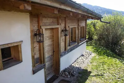 a wooden house with windows on the side of it at Chalet cosy proche Tramway du Mont-Blanc et centre in Saint-Gervais-les-Bains