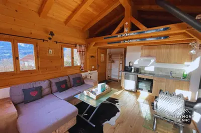a living room with a couch and a table at Chalet cosy proche Tramway du Mont-Blanc et centre in Saint-Gervais-les-Bains