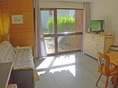 a living room with a sliding glass door to a patio at Studio coquet avec terrasse, calme et parking à Samoëns - FR-1-629-86 in Samoëns