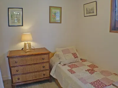 a bedroom with a bed and a dresser with a lamp at Studio coquet avec terrasse, calme et parking à Samoëns - FR-1-629-86 in Samoëns
