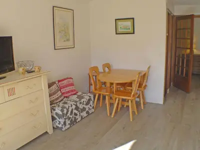 a dining room with a table and chairs and a couch at Studio coquet avec terrasse, calme et parking à Samoëns - FR-1-629-86 in Samoëns