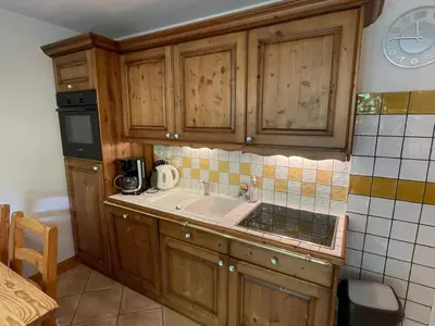 a kitchen with wooden cabinets and a sink at T3 calme à Samoëns avec Wifi et Parking - FR-1-629-45 in Samoëns