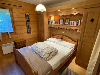 a bedroom with a bed in a wooden room at T3 calme à Samoëns avec Wifi et Parking - FR-1-629-45 in Samoëns
