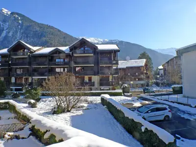 a large apartment building with snow in a parking lot at Charmant T4 à Samoëns avec Balcon et Parking, 6 Pers. - FR-1-629-87 in Samoëns